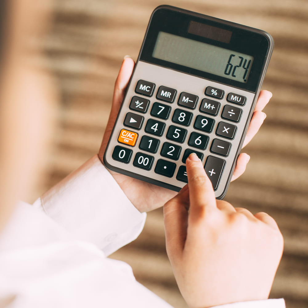 Análise tributária - foto de contador analisando impostos com calculadora em Contabilidade para Negócios Digitais